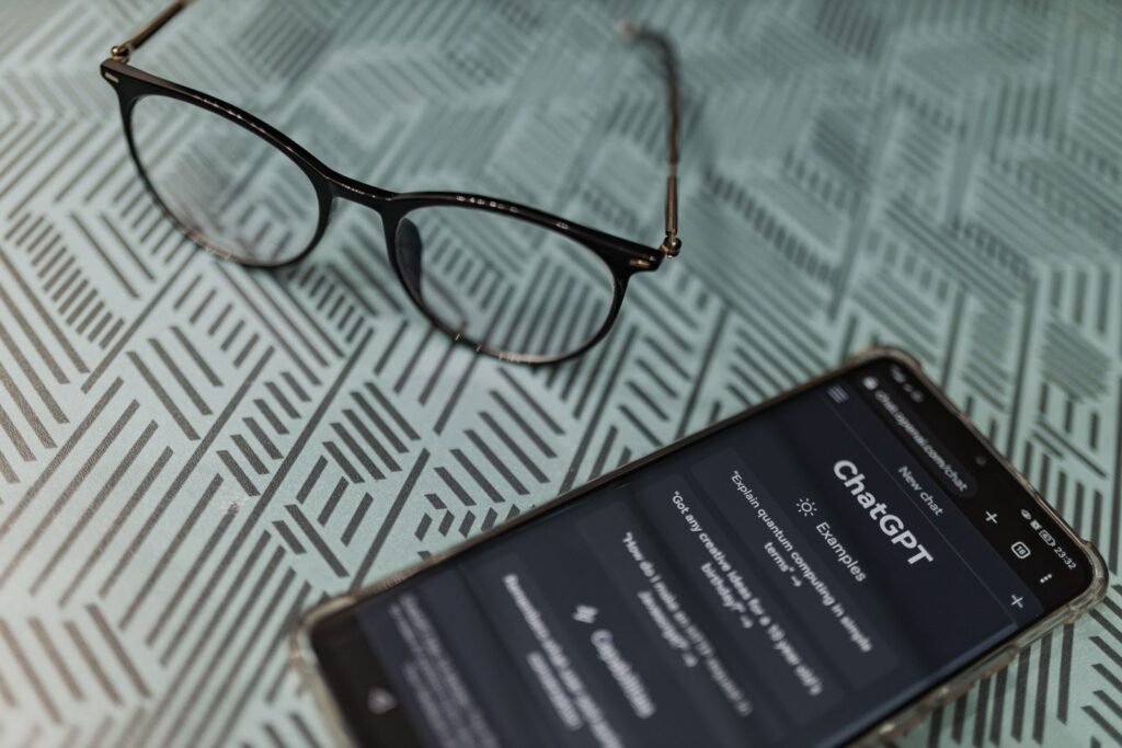 AI search visibility: ChatGPT on a smartphone next to a pair of eyeglasses